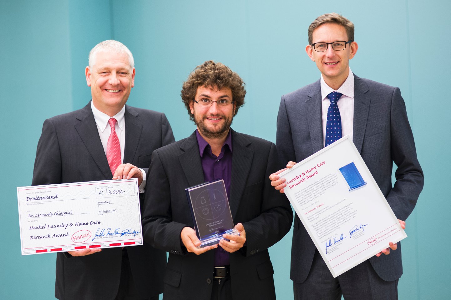 Prof. Dr. Thomas Müller-Kirschbaum (left), Head of Global Research and Development at the Laundry & Home Care business unit, and Dr. Michael Dreja, Head of Global Research at Laundry & Home Care, present the "Laundry & Home Care Research Award 2015" to Dr. Leonardo Chiappisi (center).
