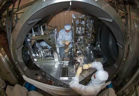 Researchers installing some of the small suspended LIGO mirrors in the vacuum system (Credit: Courtesy of LIGO Laboratory)