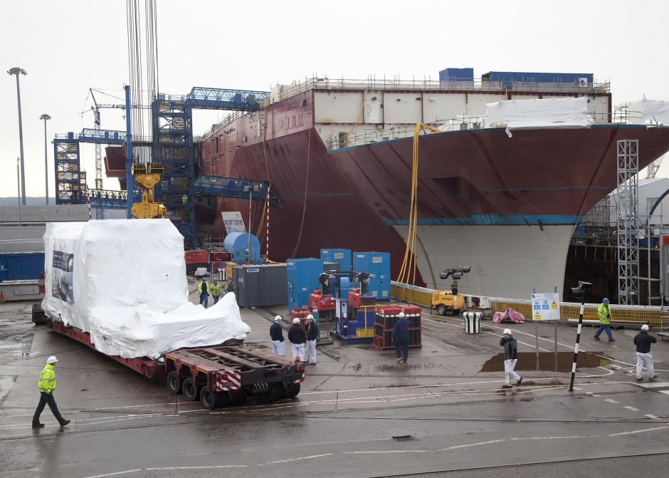 The Rolls-Royce MT30 gas turbine enclosure, shrink wrapped for protection, arrives alongside HMS Queen Elizabeth, prior to installation at Babcock’s Rosyth yard in Scotland.