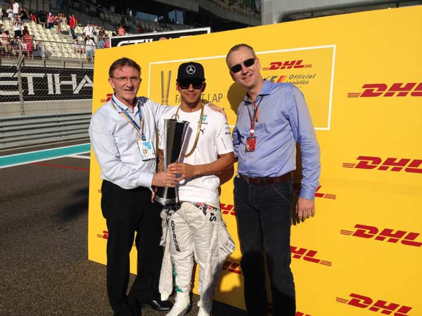 Ken Allen, CEO, DHL Express (left) and Arjan Sissing, SVP, Corporate Brand Marketing, Deutsche Post DHL (right) hand the trophy to Lewis Hamilton before the 2014 FORMULA 1 ETIHAD AIRWAYS ABU DHABI GRAND PRIX.