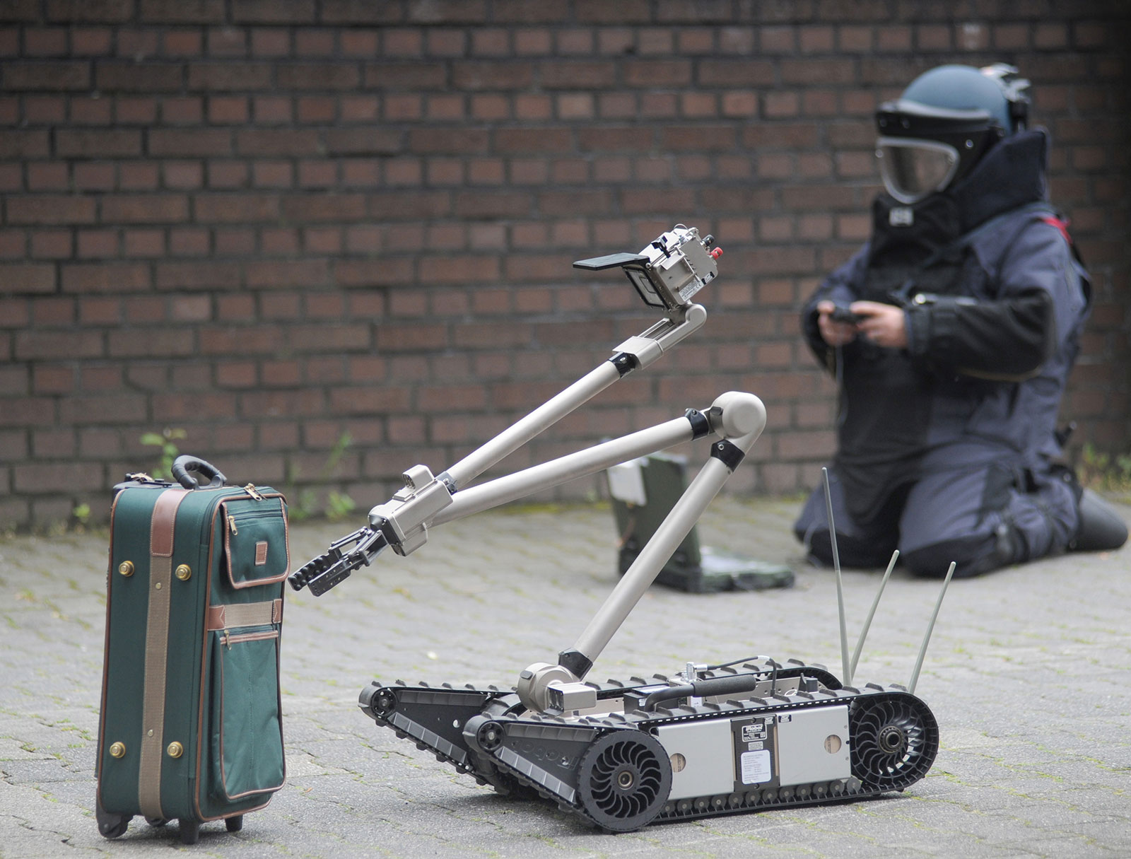 © Foto Landeskriminalamt Nordrhein-Westfalen Einsatzkräfte der Polizei entschärfen eine Kofferbombe.