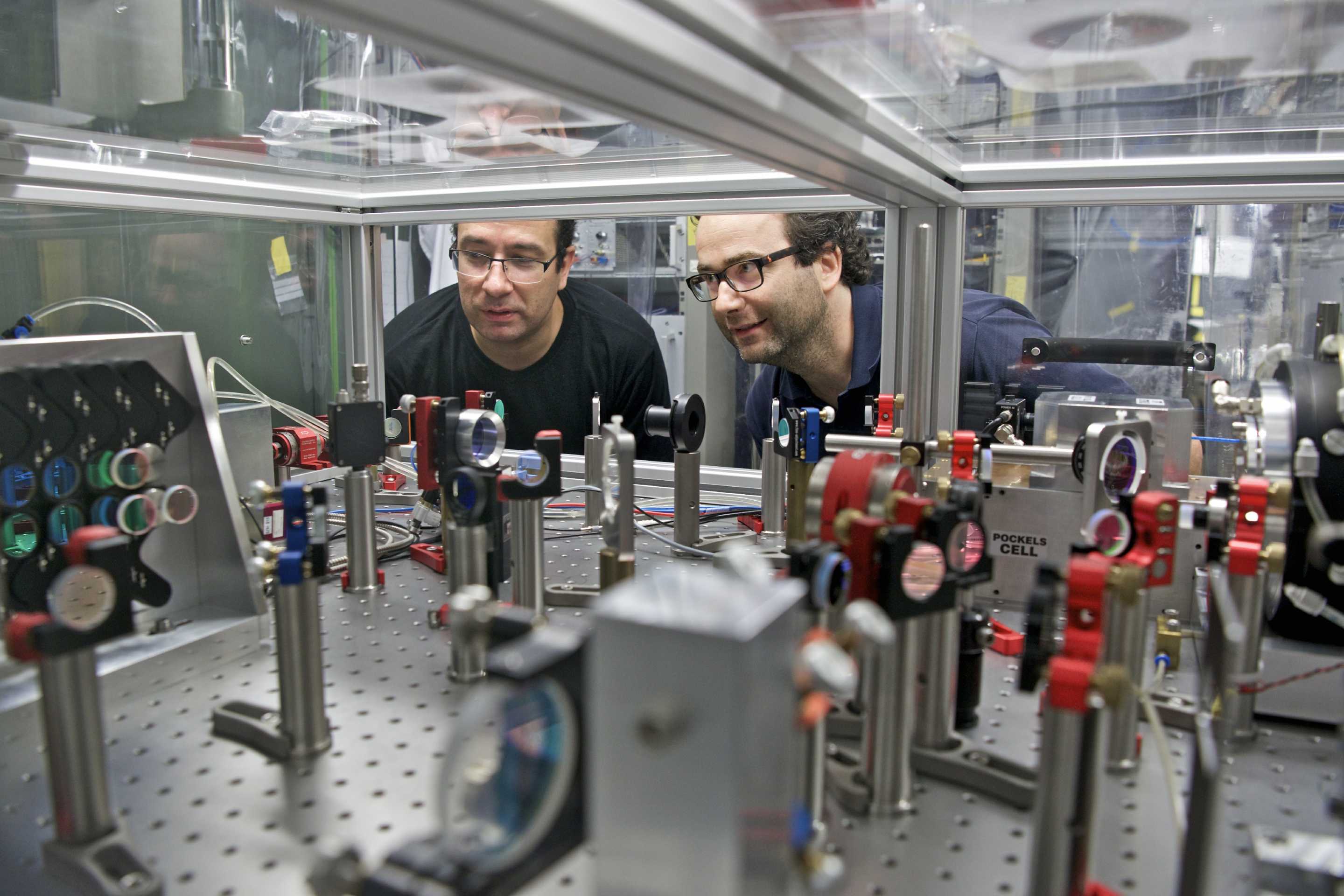 Karsten Schuhmann and Aldo Antognini at the laser system which was used for the laser spectroscopy measurements. (Photo: Paul Scherrer Institute/Markus Fischer)